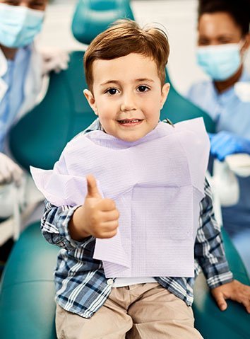 Child seated in a dental chair after a dental visit